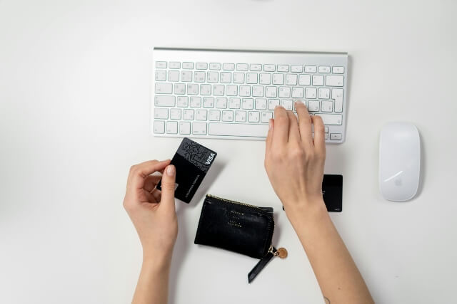 Someone Holding a credit card and typing on a keyboard