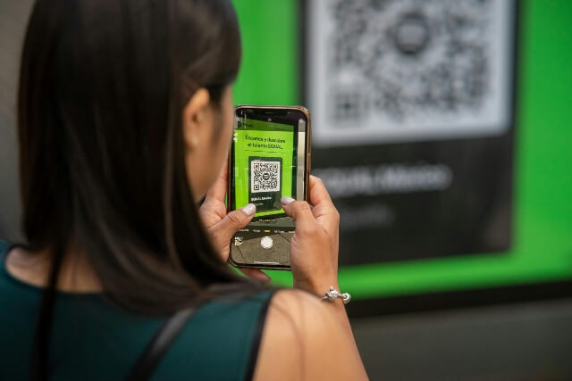 Woman using smart phone to scan a QR code